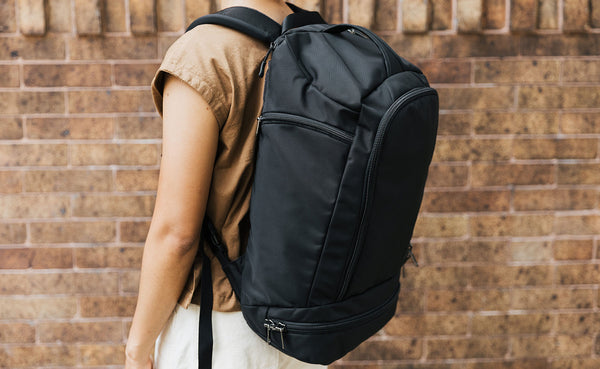 A person wearing a Black Techonaut 30 as a backpack.